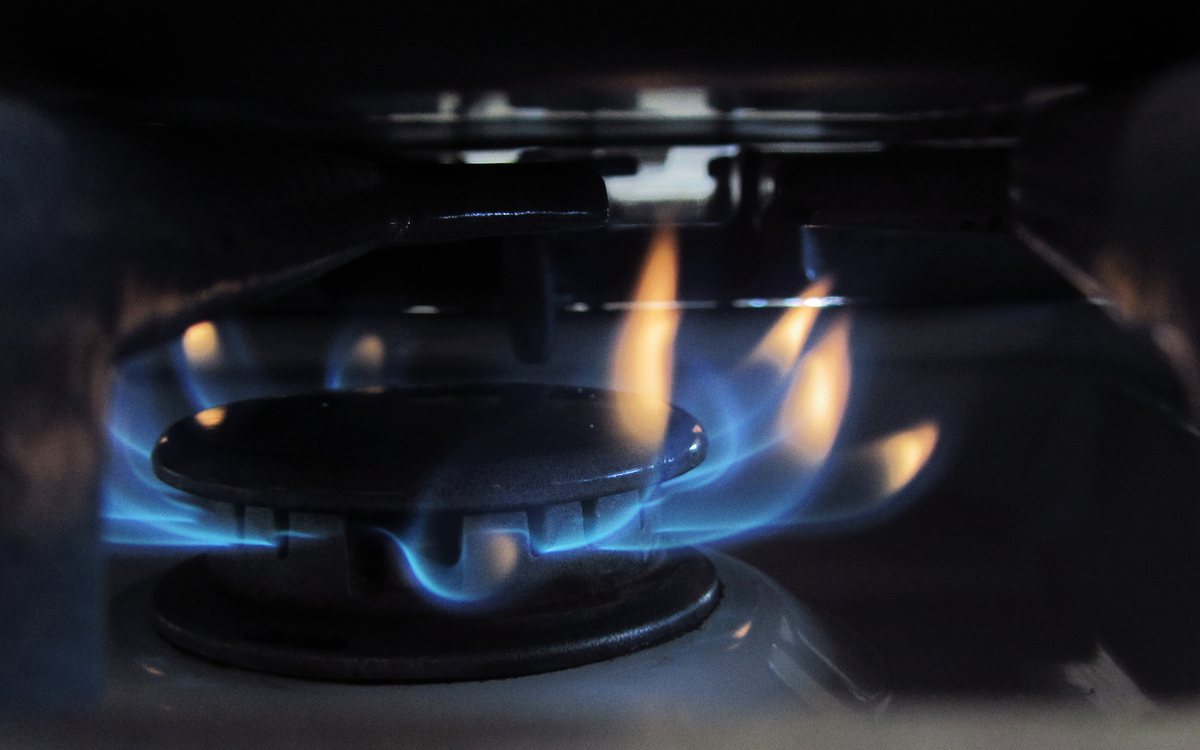Gas cooktop burner running with a blue flame ring