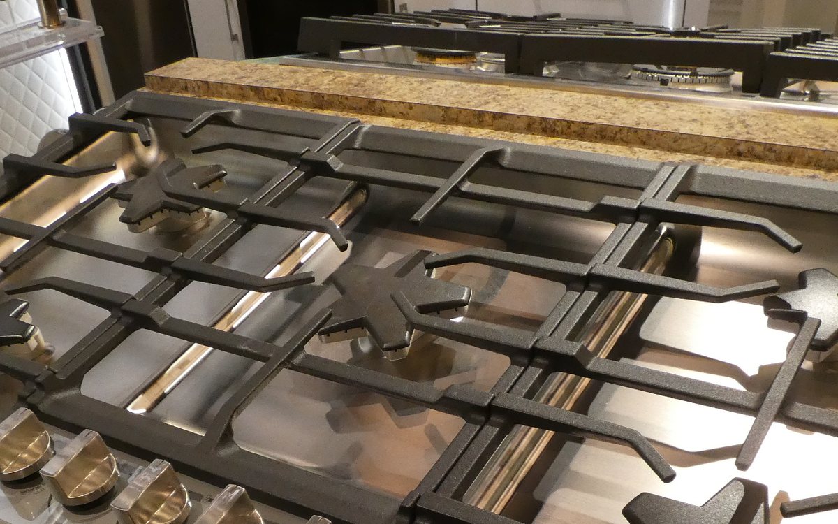 Professional-style stainless gas rangetop with heavy cast grates over star-shaped burners, of the kind we repair in Walnut Creek homes